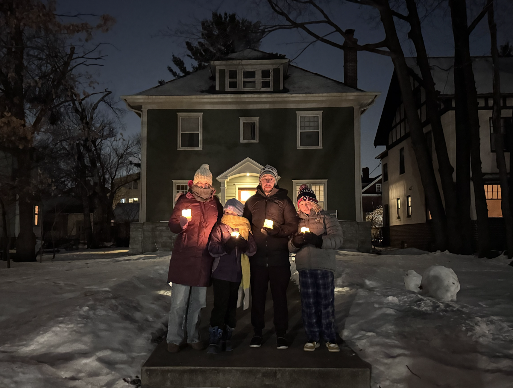 Family on doorstep with candles