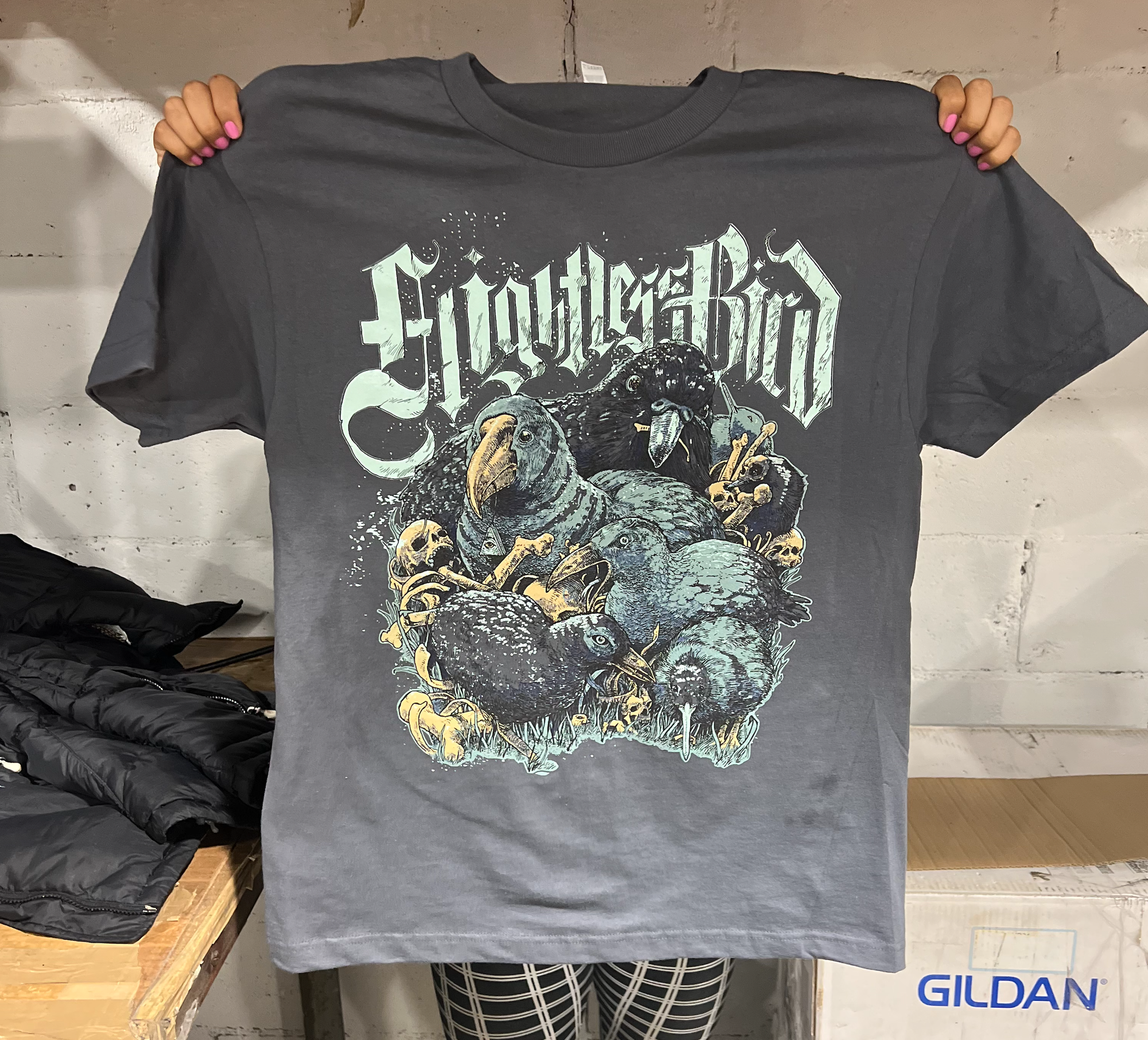 The Flightless Bird tee - a metal style tee featuring iconic NZ flightless birds surrounded by crushed skulls and bones