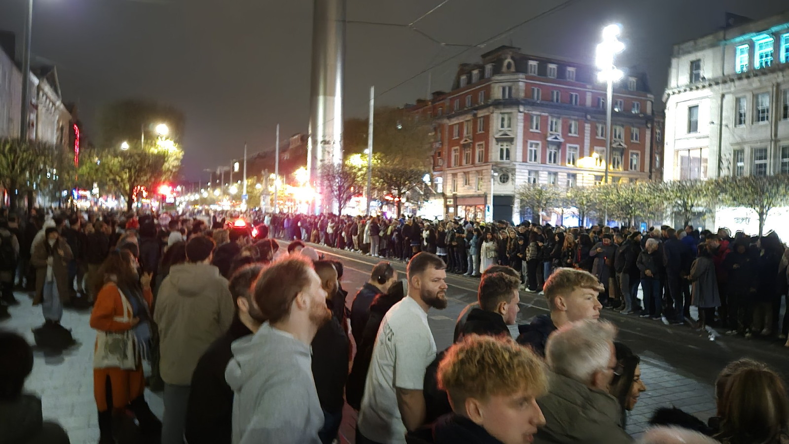 People lining up beside the road en masse