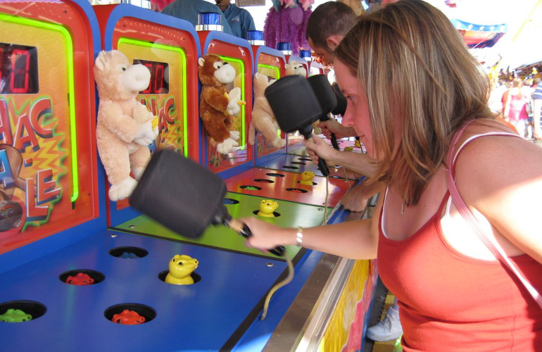 A woman furiously whacking moles